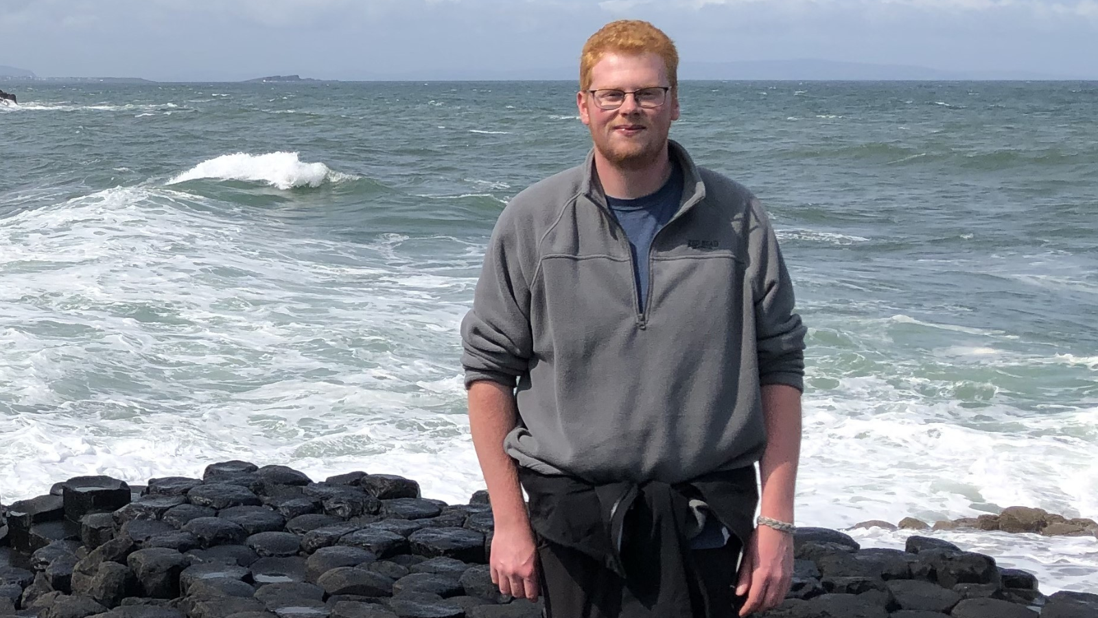 Portrait of Jared standing in front of an  ocean.